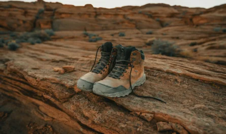 chaussures de randonnée marron et gris posées sur roche désertique
