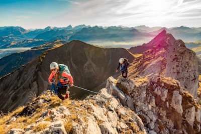 2 men hiking on mountain during daytime