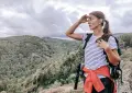 a woman standing on top of a mountain with a backpack