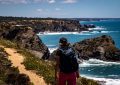 Randonneuse sur le sentier côtier du GR34 en Bretagne, falaises et mer turquoise