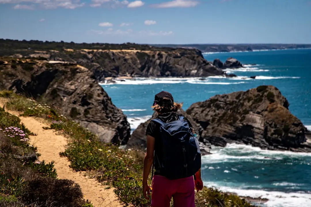 Randonneuse sur le sentier côtier du GR34 en Bretagne, falaises et mer turquoise