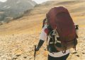 Hiker with large backpack on a rocky mountain trail
