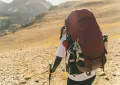 Hiker with large backpack on a rocky mountain trail