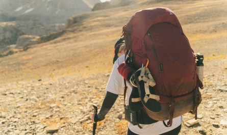 Hiker with large backpack on a rocky mountain trail